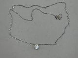 silver chain with a diamond pendant on it on a white surface