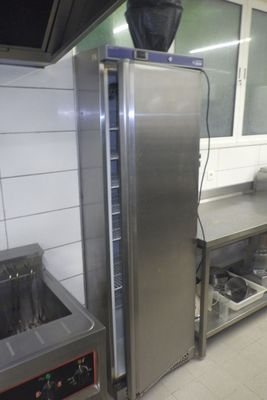 un réfrigérateur en acier inoxydable dans une cuisine équipée d'un évier et d'une cuisinière