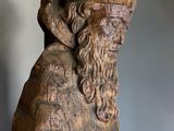 statue of a man with a beard and a hat holding a book