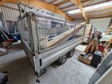 a truck with a cage on the back of it in a garage