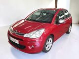 the small red car is parked in a white room