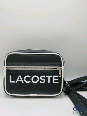 un sac à bandoulière noir et blanc sur lequel est inscrit « Lacoste »