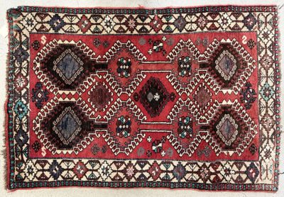 un gros plan d'un tapis rouge et bleu posé sur une surface blanche