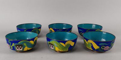 quatre bols bleus ornés de motifs de dragons, posés sur une surface blanche
