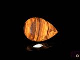 a close up of a tiger eye stone on a black surface