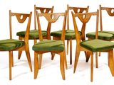 six wooden chairs with green cushions on them