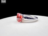 silver ring with a red stone on a white surface