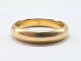 a close up of a gold ring on a white surface