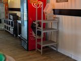 une pièce équipée d'une table, de chaises et d'un réfrigérateur