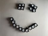 a smiley face made out of dice pieces on a white surface