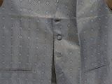 a blue vest with a pattern on it hanging on a wall