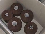 a box of chocolate donuts sitting on the floor