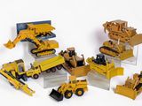 de nombreux engins de chantier miniatures posés sur une surface blanche