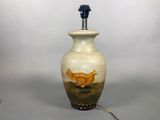 a lamp that has a bird on it on a table