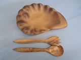 deux cuillères en bois et une assiette en bois posées sur une table