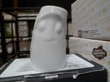 une figurine en céramique blanche posée sur une boîte