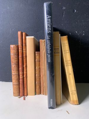 une pile de livres posée sur une table près d'un mur noir