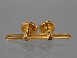 a close up of a pair of gold cufflinks on a table