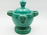 green ceramic bowl with a lid and a face on the lid