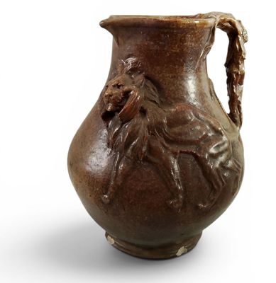 un vase marron orné d'une tête de lion