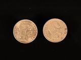 two british coins on a black background