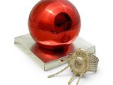 a red ornament sitting on top of a stack of books