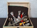 a wooden box with silverware in it on a table