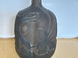 un vase avec un oiseau posé sur une table