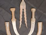 three knives and a knife holder on a black cloth