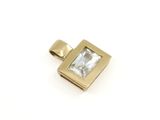 un gros plan d'un petit pendentif en forme de diamant carré sur fond blanc