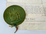 un cachet de cire vert sur lequel figure l'image d'un homme