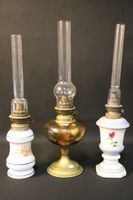 Lot de trois lampes à pétrole, une en laiton et verre ambré …