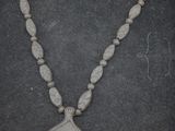 un gros plan d'un collier orné de perles sur un fond noir