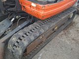 an orange excavator that is sitting in the dirt