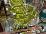 a glass display case filled with green vases and other glassware