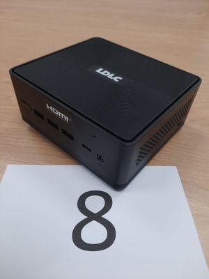 une petite boîte noire posée sur une table, à côté d'un chiffre 8