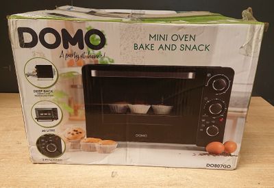 emballage d'un four à micro-ondes noir posé sur une table en bois