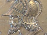 a gold plate with a picture of a man in a helmet on it