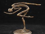 une sculpture en bronze représentant un homme sur un skateboard, sur fond noir