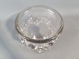 a small glass bowl sitting on a white surface