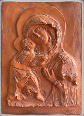 une image représentant une plaque sur laquelle figure une femme tenant un enfant dans ses bras