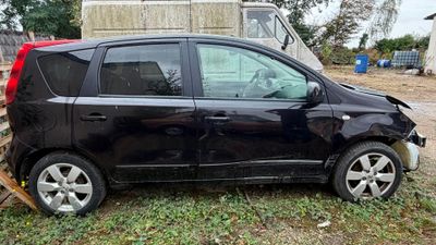 une photo d'une voiture endommagée, garée dans l'herbe