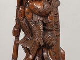 wooden statue of a man with a hat and a bird on his shoulder