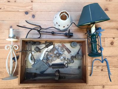 une photo d'une table sur laquelle se trouvent une lampe, un abat-jour et quelques outils