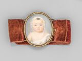 une image représentant un petit portrait d'un bébé portant un nœud en velours rouge