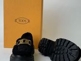 the black shoes are next to a yellow box on a white surface