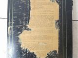 un vieux livre posé sur un sol carrelé, près d'un mur
