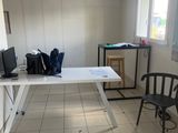 une pièce dans laquelle se trouvent une table, des chaises et une télévision
