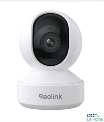 un gros plan d'une caméra posée sur un trépied, sur laquelle figure le mot « Reolink »