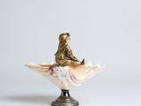 a figurine of a little girl sitting on a shell